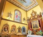 Wnętrze kościoła z widokiem na ołtarz boczny z wizerunkiem św. Antoniego. Widzimy również polichromowany sufit - malowidło przedstawiające krzyż. Pod ścianą stoją feretrony, które obnosi się podczas procesji.