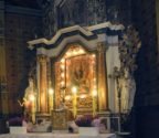 Ołtarz główny oświetlony lampkami i świecami.