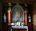 Ołtarz główny z obrazem Matki Bożej Częstochowskiej. Wokół obrazu wiszą wota ofiarne.
