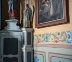 Detale we wnętrzu kościoła. Na ścianie obraz przedstawiające św. Annę nauczającą Marię. Ściny są polichromowane.