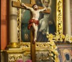 Ołtarz boczny z obrazem przedstawiającym św. Józefa, trzymajacego na rękach małego Jezusa. na pierwszym planie krucyfiks stojący na ołtarzu.