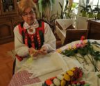 Marianna Pokora w swoim mieszkaniu. Na stole leżą jej prace - kwiaty z bibuły, palmy, serwetki.